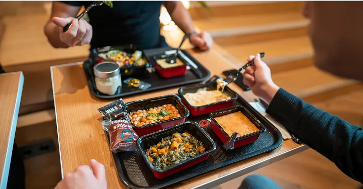 Masasında yemek yiyen iki kişi görseli