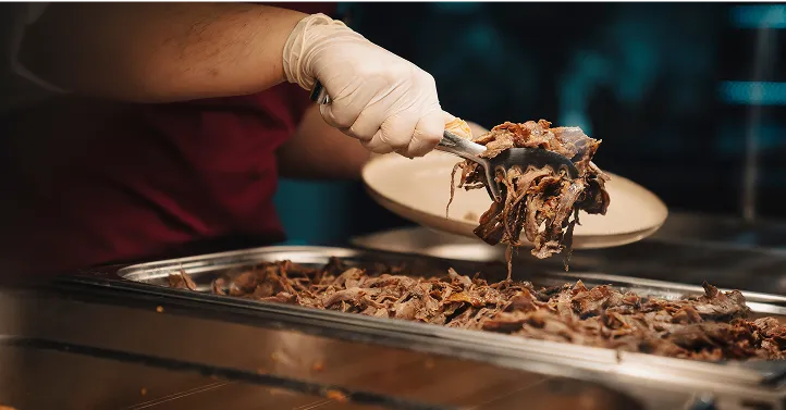 Tabağa servis edilecek yemeği koyan çalışan görseli