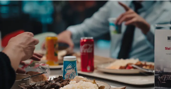 Masada yemek yiyen iki çalışan görseli