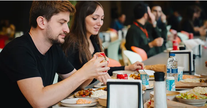 Masada yemek tüketen kişilerin görseli